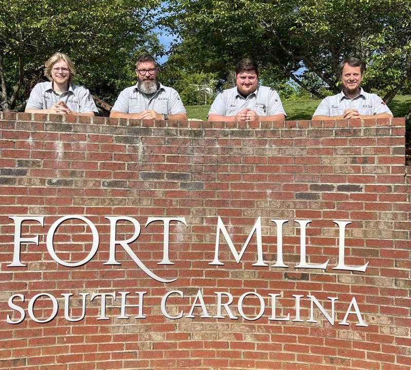 Electricians in front of Fort Mill sign